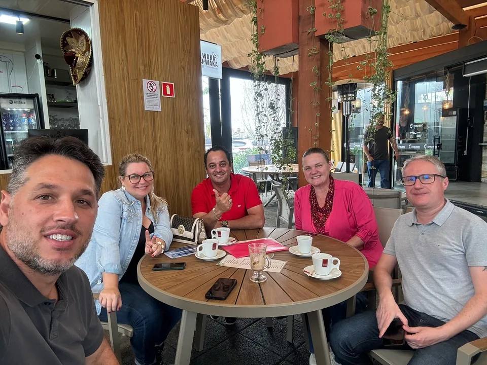 Samuel, Greice e parceiros reunidos à mesa de um café